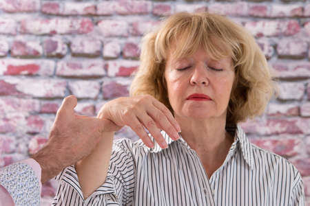 Hypnotist  hypnotizing a senior womanの写真素材