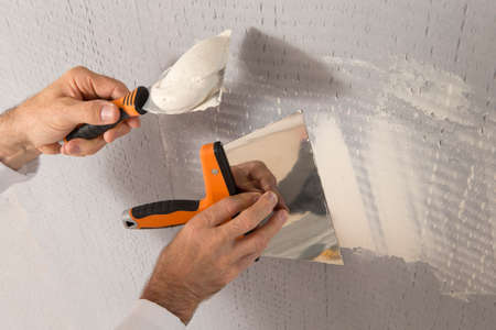 manual worker with wall plastering tools inside a houseの写真素材