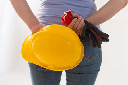 Close up back-view of woman builder with hardhat in handsの写真素材