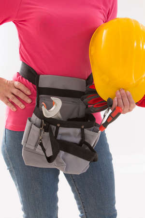 Close up of woman builder with hardhat in hands and tools beltの写真素材