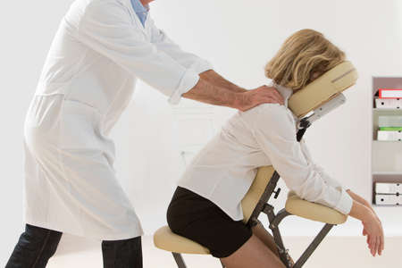 Woman having back massage in medical or business officeの写真素材