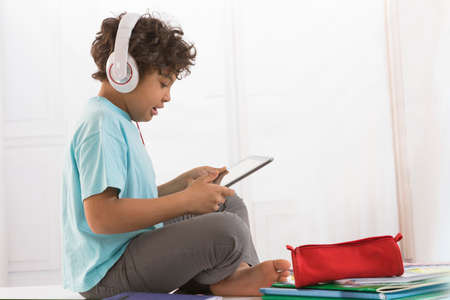 kid sit on the floor using internet device