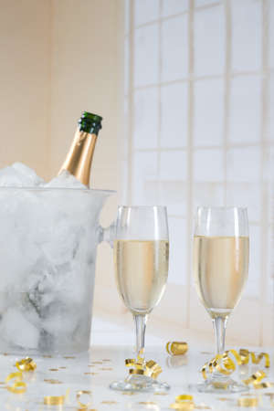 Glasses of champagne and bottle with festive backgroundの写真素材