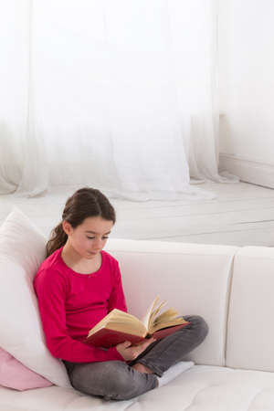 young  girl is reading a bookの写真素材