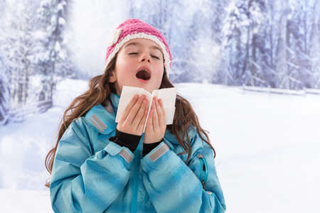 the flu illness, a young girl sneezes diseaseの写真素材