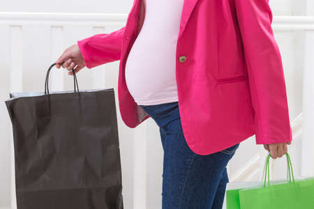 Asian Pregnant woman holding paper bag, shopping concept in white background