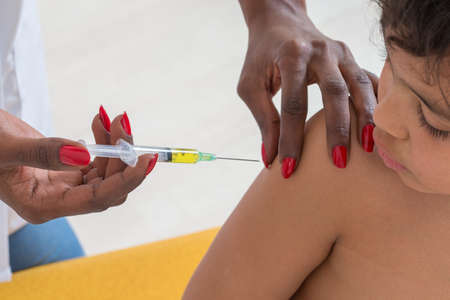 doctor vaccinating a childat his officeの写真素材