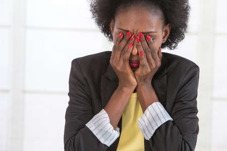 Portrait of mature black woman stressed at workの写真素材