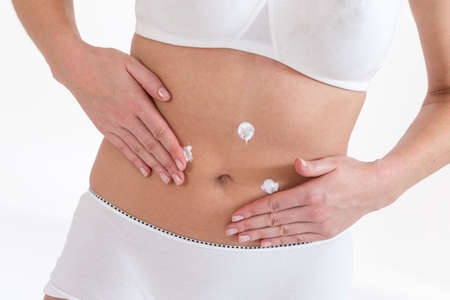 Woman apply body cream on abdomenの写真素材