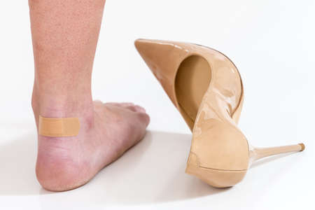 female having pain after wearing high heeled shoesの写真素材