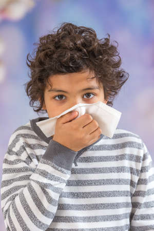 Kid blowing his nose Seasonal virusの写真素材