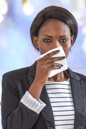 african business  woman blowing her nose