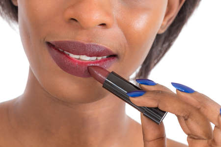 black woman with glamour lips applying lipstickの写真素材