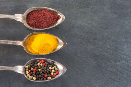 metal spoons with various ground spices and herbsの写真素材