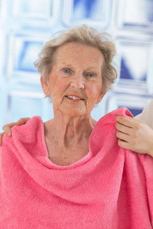 Care giver or nurse givng assistance to elderly woman for showerの写真素材