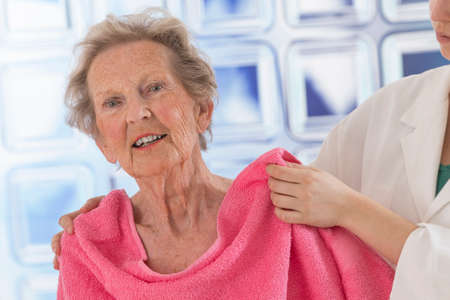 Care giver or nurse givng assistance to elderly woman for showerの写真素材