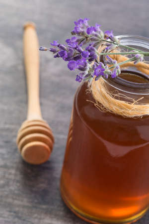 Honey in jar with honey dipper on vintageの写真素材