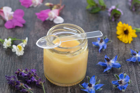 raw organic royal jelly in a small bottle on slate boardの写真素材