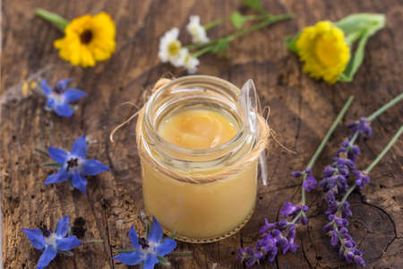 raw organic royal jelly in a small bottle on s wooden boardの写真素材