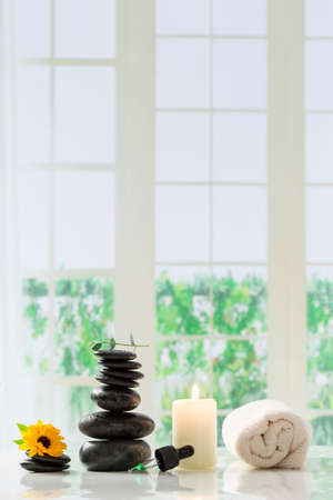 Spa setting with hot stones, candle,ans aroma oil