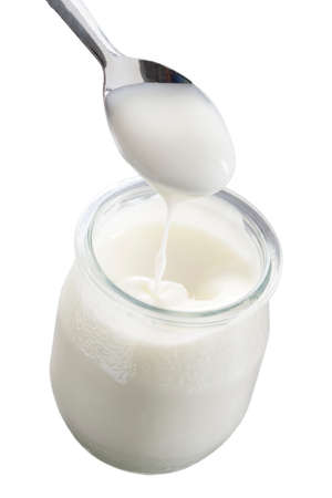 glass pot of yogurt with spoon isolated on white backgroundの写真素材