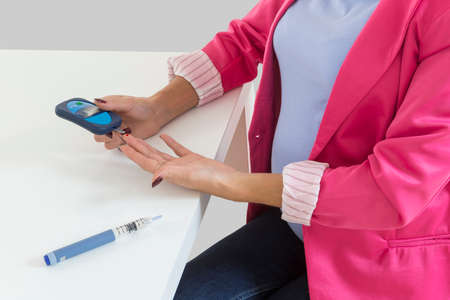 Pregnant woman taking a blood sample from her fingerの写真素材