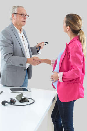 Close-up Of Pregnant Woman Shaking Hands With Doctorの写真素材