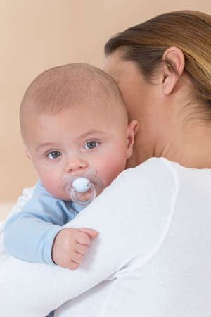 young mother holding a baby boy in her arms