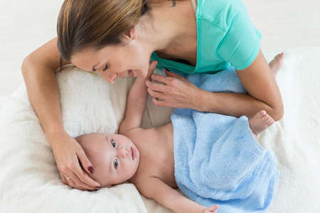 happy mother playing with her baby after having bathed