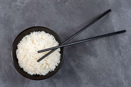 Bowl of rice and chopsticks isolated on white background with selective focusの写真素材