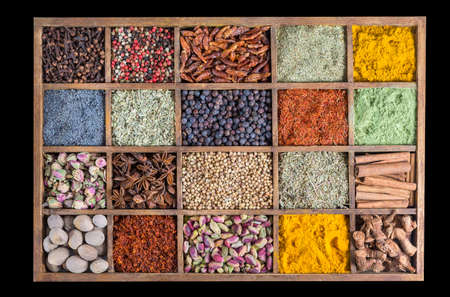 wooden box with spices and herbs on black backgroundの写真素材