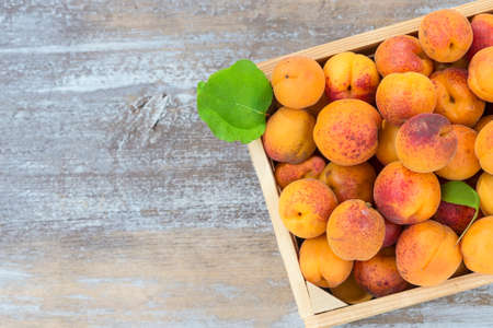 wood box with apricots on a old wooden background Top viewの写真素材
