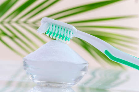 Top view of baking soda bowl with tooth brush on white