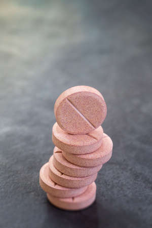 Stack of vitamin mineral supplement effervescent tablets on slate backgroundの写真素材