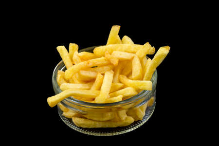 glass bowl of french fries on black background