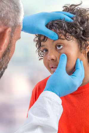 ophthalmology. eyes exam, male doctor examining teen patien teyes