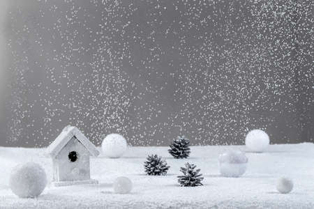 white Christmas background with a blowing snow over on grey background, bauble, house, pine coneの写真素材