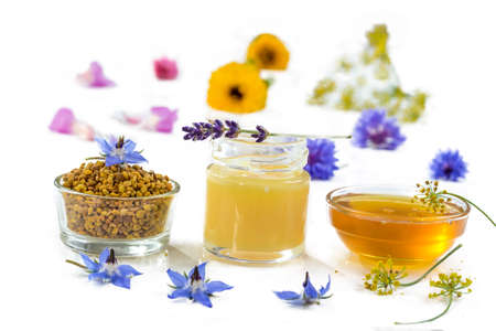 variety of raw organic honey bee products board surrounded by flowers on white backgroundの写真素材