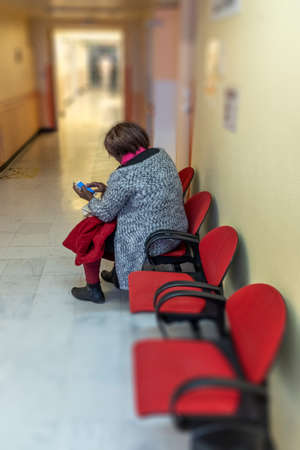 lonely woman sitting in doctors waiting roomの写真素材