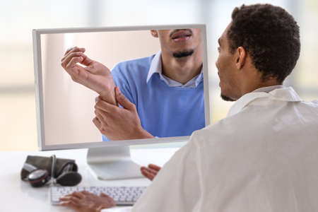 Doctor with a stethoscope on the computer laptop screen. Telemedicine or telehealth concept, wrist...