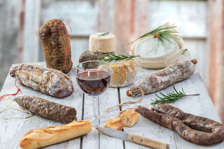 Corsican wild pork delicatessen, and cheese made in Corsica France on wooden background with glass...