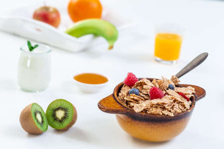 Healthy breakfast with bowl of cereal, orange juice, milk and fruits on white background.の写真素材