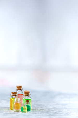 bottles of colored aromatherapy oils isolated. on grey copy text