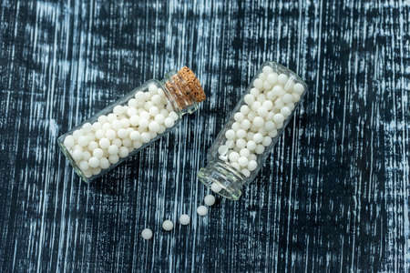 Still life concept of homeopathic pills with homeopathy granules on a grey wooden backgroundの写真素材