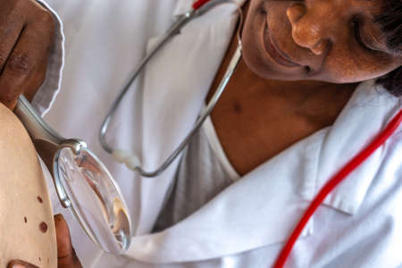Elderly woman getting check-up at dermatologist.,usig magnifying glassの写真素材