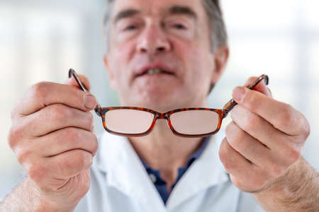 vision deficit-doctor suggesting eyeglasses for person with refocused vision, sight improvement.の写真素材
