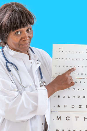 Ophthalmologist checking patient eyesight, pointing letters, eyes examination at officeの写真素材