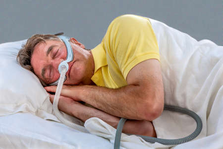 Man sleeping apnea and CPAP machineの写真素材
