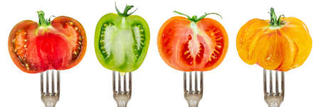 Collection of half tomatoes on forks aligned and isolated on whiteの写真素材