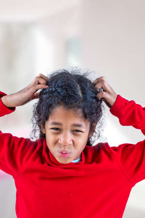 girl itchy her hair on isolated w indoors background, health care conceptの写真素材